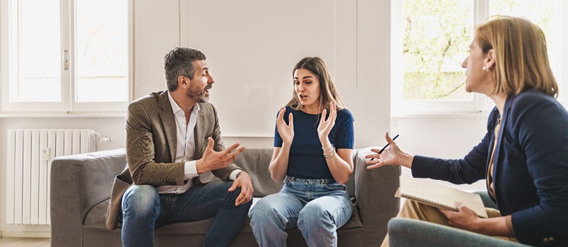 Couple fighting in front of the counselor in the counseling session