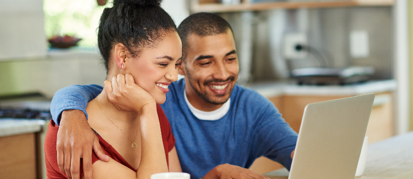 Happy couple watching something together on a computer