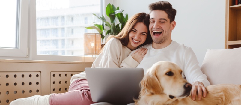 Cheerful couple watching movie on laptop 