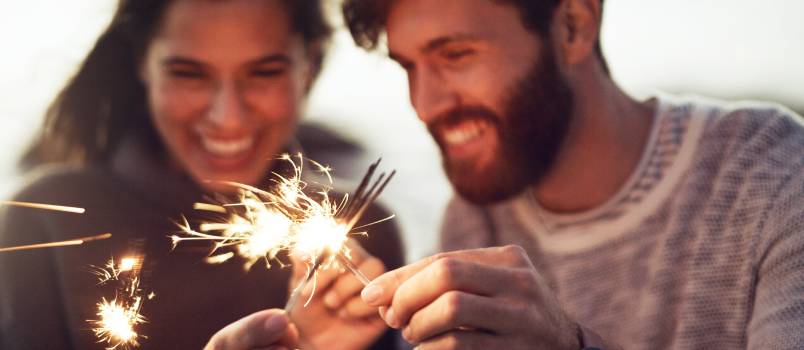 Couple holding sparkles on the beach  